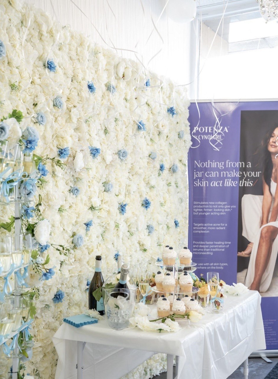 Inside Pureté Medical Spa — floral wall and champagne table
